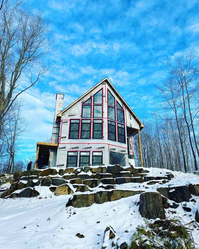 A modern glass-fronted home under winter wrap on a rock outcrop, a BRADY new-construction project.
